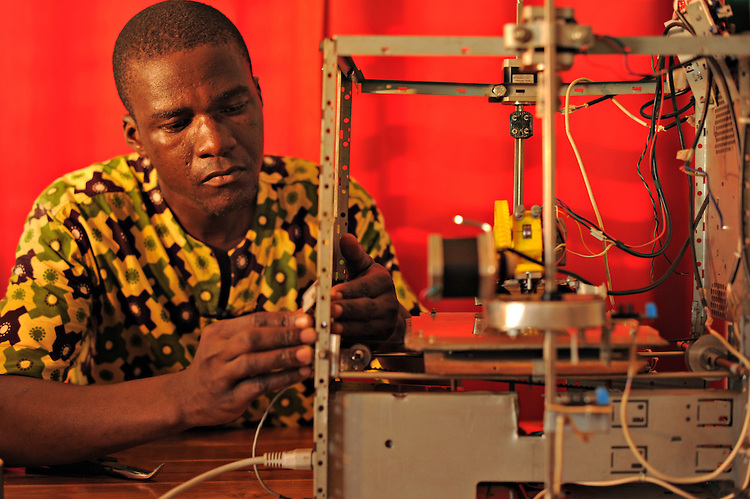 LOME, TOGO  13-05-31   -  Kodjo Afate Gnikou and his $100 US 3D printer W.AFATE, which is largely made of e-waste, in Lome, Togo on May 31, 2013. Gnikou dreams of sending a larger version to Mars to print tools and homes for future colonizations. "They all say it is merely a dream and it will never happen," says Gnikou, pointing out that there are already robots on Mars. "I really want my 3D printer to be the first on Mars so people can say it was an African who had the idea to put a 3D printer on Mars."  Photo by Daniel Hayduk
